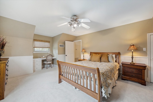 carpeted bedroom featuring vaulted ceiling, built in desk, and ceiling fan