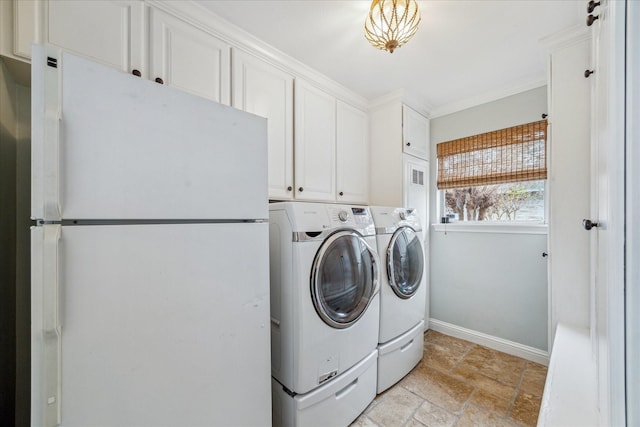 laundry area featuring cabinets, washer and dryer, and crown molding