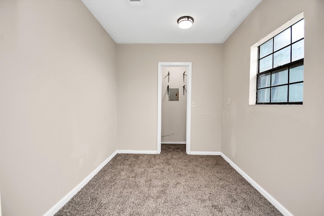 empty room with electric panel and light colored carpet