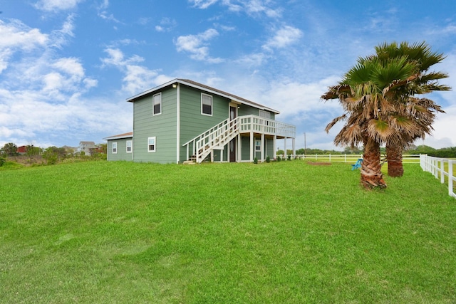 rear view of house featuring a yard and a wooden deck