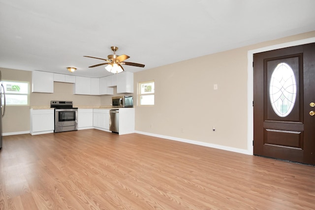 foyer with ceiling fan, a wealth of natural light, and light hardwood / wood-style flooring