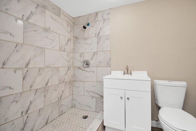 bathroom with vanity, a tile shower, and toilet