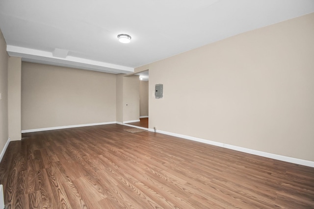 empty room with hardwood / wood-style flooring and electric panel