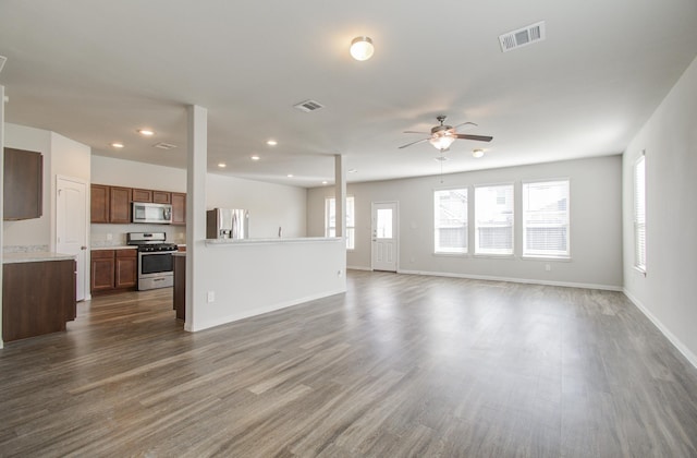 unfurnished living room featuring ceiling fan and dark hardwood / wood-style floors