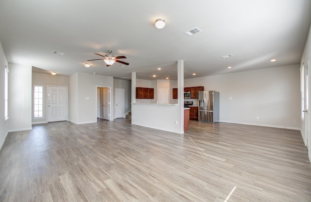 unfurnished living room featuring ceiling fan and light hardwood / wood-style floors