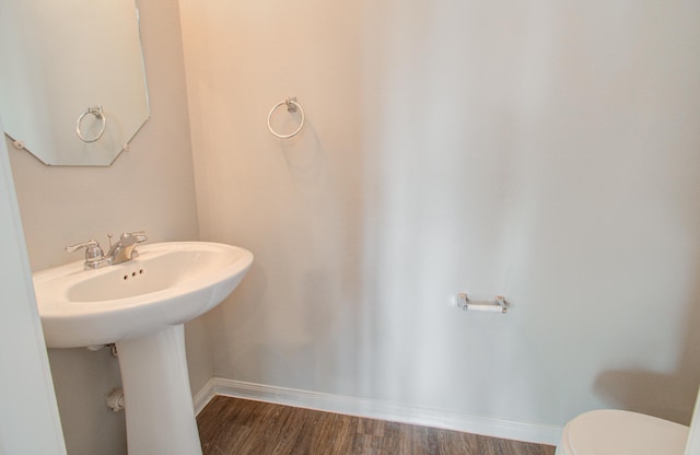 bathroom with toilet and wood-type flooring