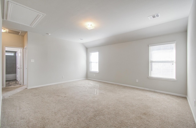 unfurnished room with light carpet and lofted ceiling