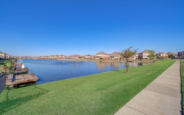 dock area with a water view and a lawn