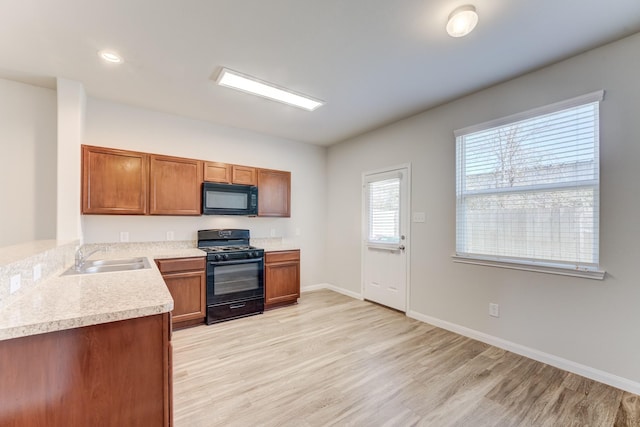 kitchen with light hardwood / wood-style flooring, sink, and black appliances