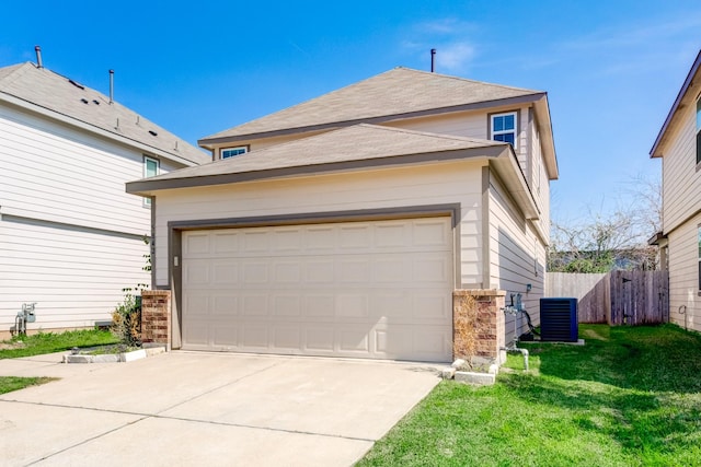 garage with central air condition unit and a yard