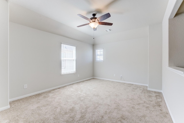 empty room with ceiling fan and light carpet