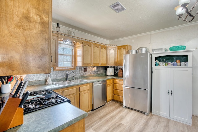 kitchen featuring stainless steel appliances, light hardwood / wood-style floors, sink, backsplash, and crown molding