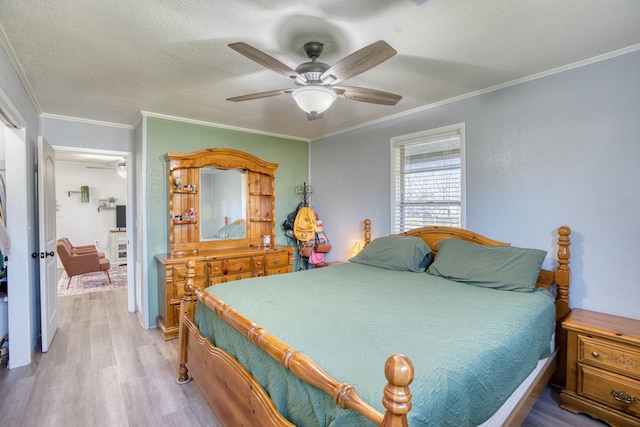 bedroom featuring hardwood / wood-style flooring, ceiling fan, crown molding, and a textured ceiling