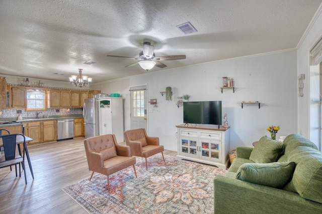 living room with sink, ornamental molding, a textured ceiling, and light hardwood / wood-style floors