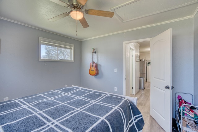 bedroom with light wood-type flooring, crown molding, and ceiling fan