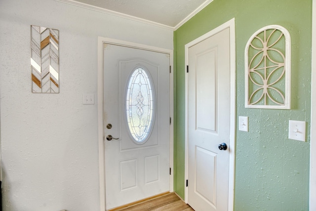 entrance foyer with ornamental molding and light hardwood / wood-style flooring