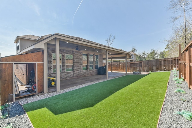 view of yard with a fenced backyard, a patio, and ceiling fan