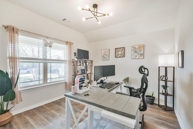 office space with baseboards, visible vents, wood finished floors, and a notable chandelier