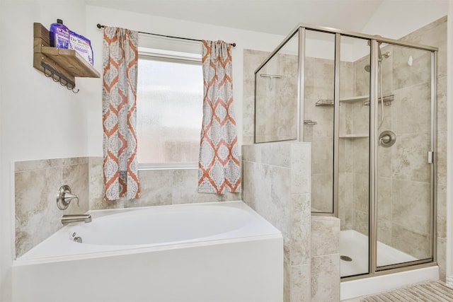 full bathroom with a bath and a shower stall