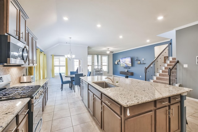 kitchen with a sink, appliances with stainless steel finishes, crown molding, and baseboards