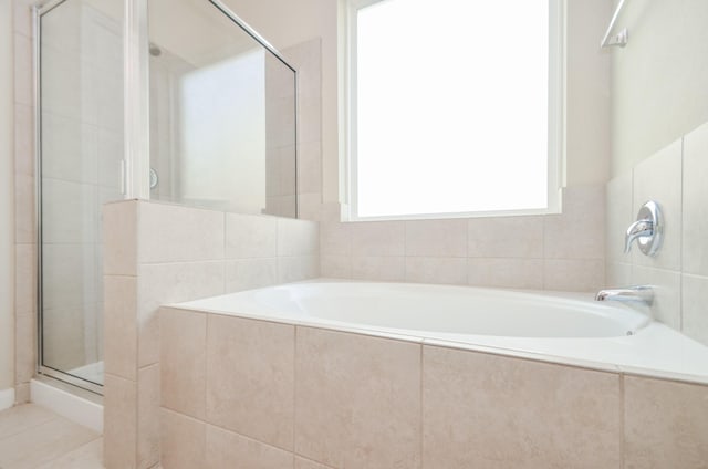 bathroom with separate shower and tub and tile patterned flooring