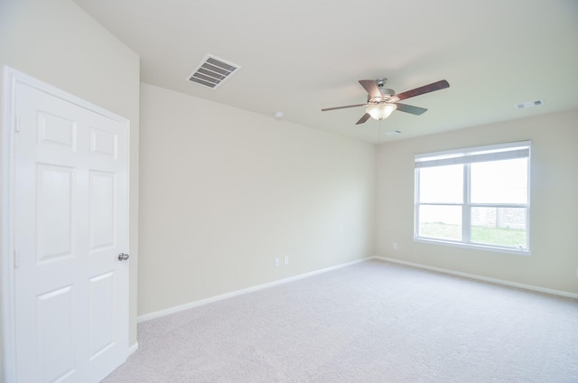 carpeted spare room with ceiling fan