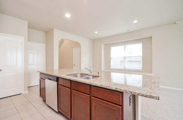 kitchen with light tile patterned flooring, sink, dishwasher, and light stone counters