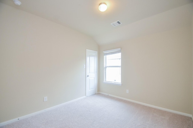 unfurnished room with light carpet and vaulted ceiling