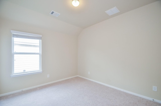 unfurnished room with vaulted ceiling and light colored carpet