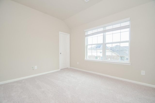 spare room with carpet and lofted ceiling