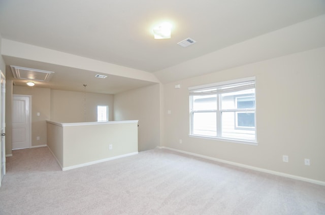 carpeted empty room with vaulted ceiling