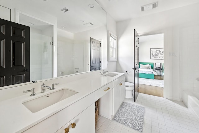 bathroom with vanity, toilet, tile patterned floors, and a shower