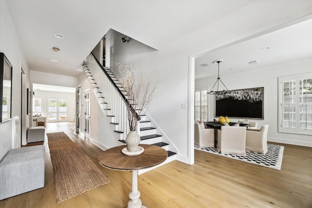 foyer entrance featuring a notable chandelier and wood-type flooring