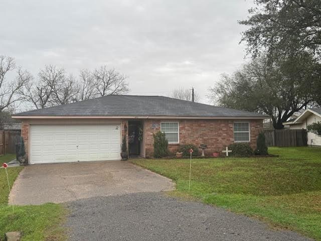 single story home with a garage and a front yard