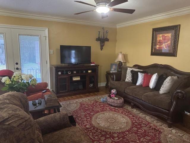 living room featuring crown molding, ceiling fan, and wood-type flooring