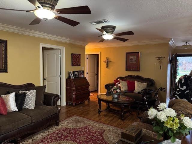 living room featuring ornamental molding, hardwood / wood-style flooring, and ceiling fan