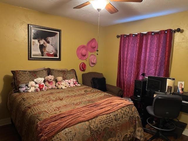 bedroom featuring ceiling fan and a textured ceiling