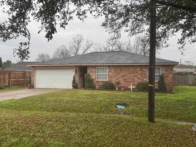 ranch-style house featuring a front lawn and a garage