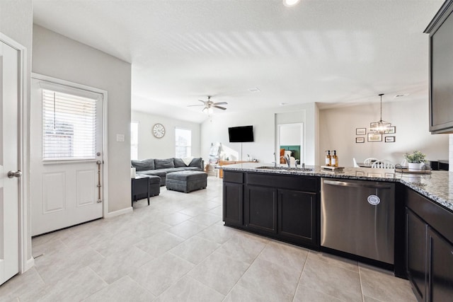 kitchen with light stone counters, hanging light fixtures, open floor plan, a sink, and dishwasher