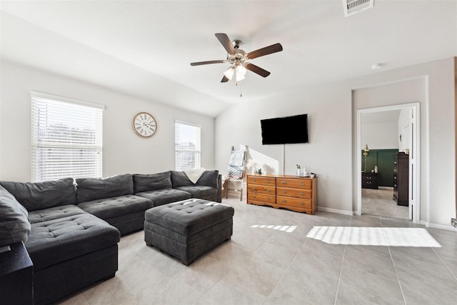 living room featuring ceiling fan, light tile patterned flooring, visible vents, baseboards, and vaulted ceiling