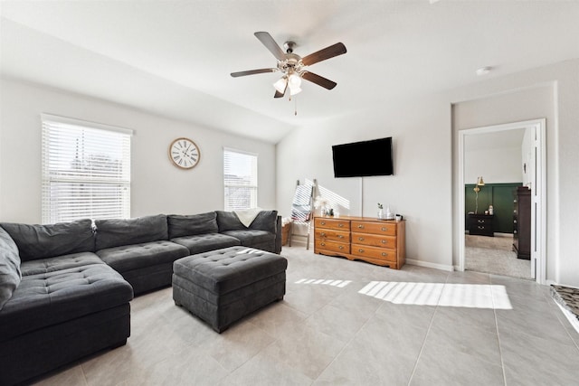 living room with ceiling fan, light tile patterned flooring, lofted ceiling, and baseboards