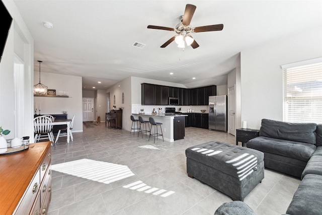 living room with ceiling fan, light tile patterned floors, recessed lighting, visible vents, and baseboards