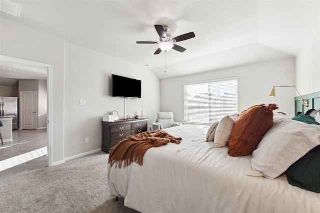 bedroom featuring visible vents, freestanding refrigerator, light carpet, vaulted ceiling, and baseboards