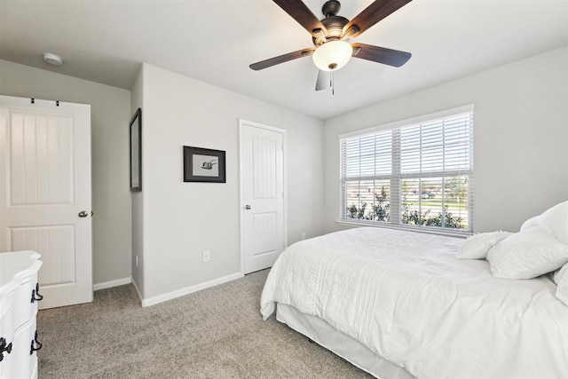 bedroom featuring baseboards, a ceiling fan, and light colored carpet