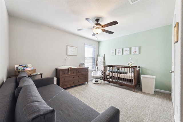 bedroom featuring light colored carpet, ceiling fan, and baseboards