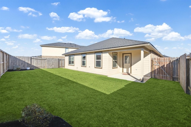 rear view of property featuring a fenced backyard, a lawn, and a patio