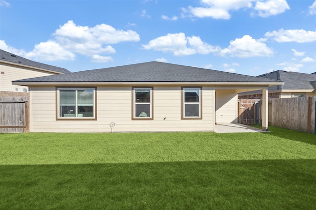 rear view of house featuring a yard, fence, a shingled roof, and a patio