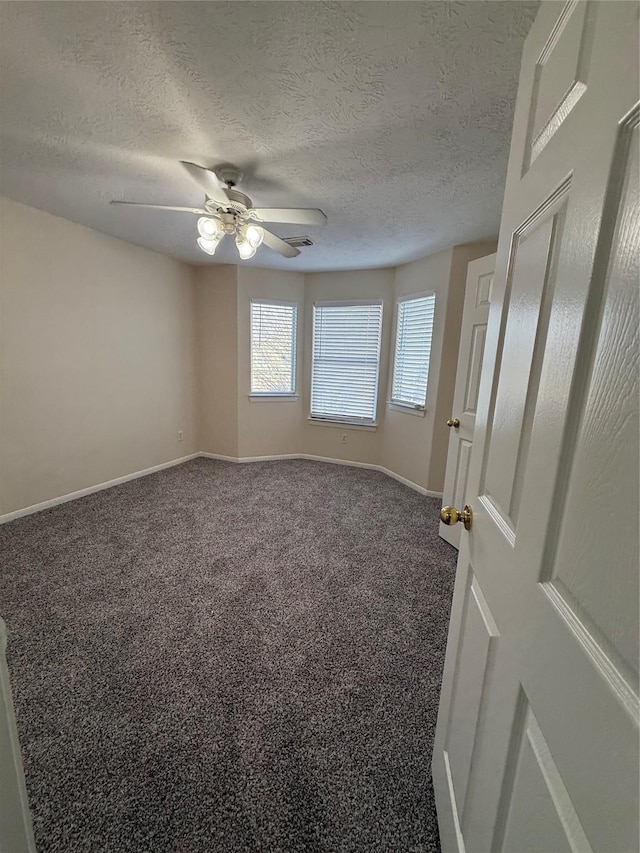 carpeted spare room with ceiling fan and a textured ceiling