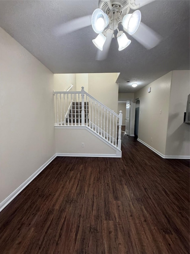 spare room featuring a textured ceiling, ceiling fan, and dark hardwood / wood-style flooring