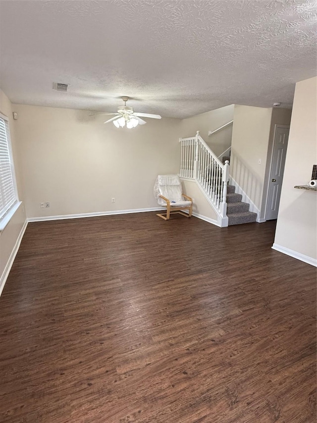 unfurnished room with ceiling fan, a textured ceiling, and dark hardwood / wood-style flooring